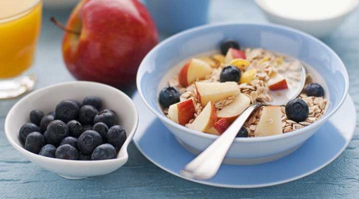 a bowl of oats with apple and blueberries
