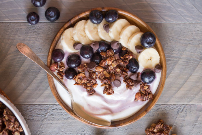 bowl of yogurt with bananas, granola and blueberries on top