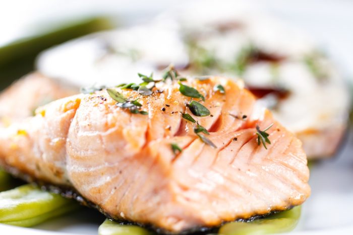 A close up of a cooked salmon fillet with seasoning on top