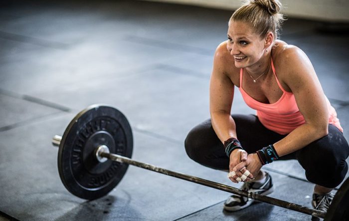 woman smiling with a barbell