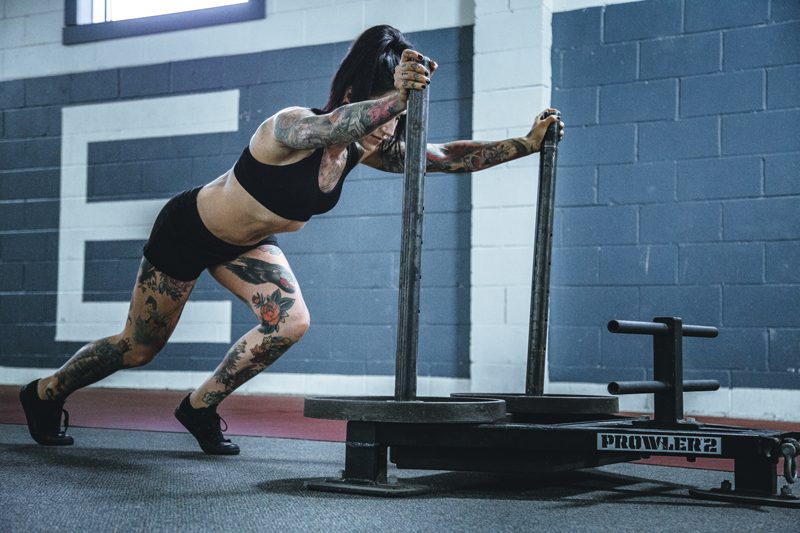 Woman pushing prowler to build muscle